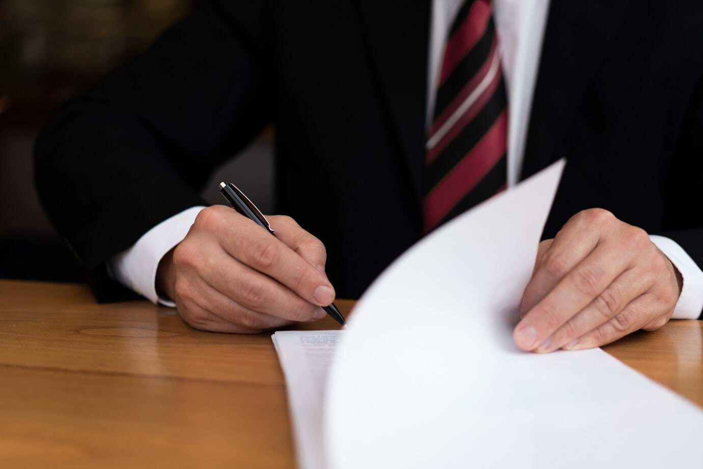 Business professional signing a document.